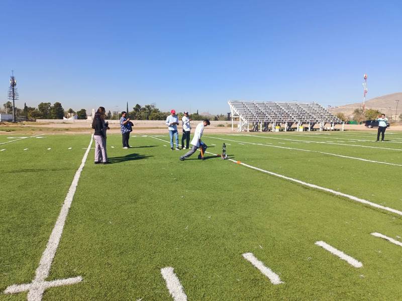 Destacan jóvenes en actividad de ciencias con lanzamiento de cohetes.
